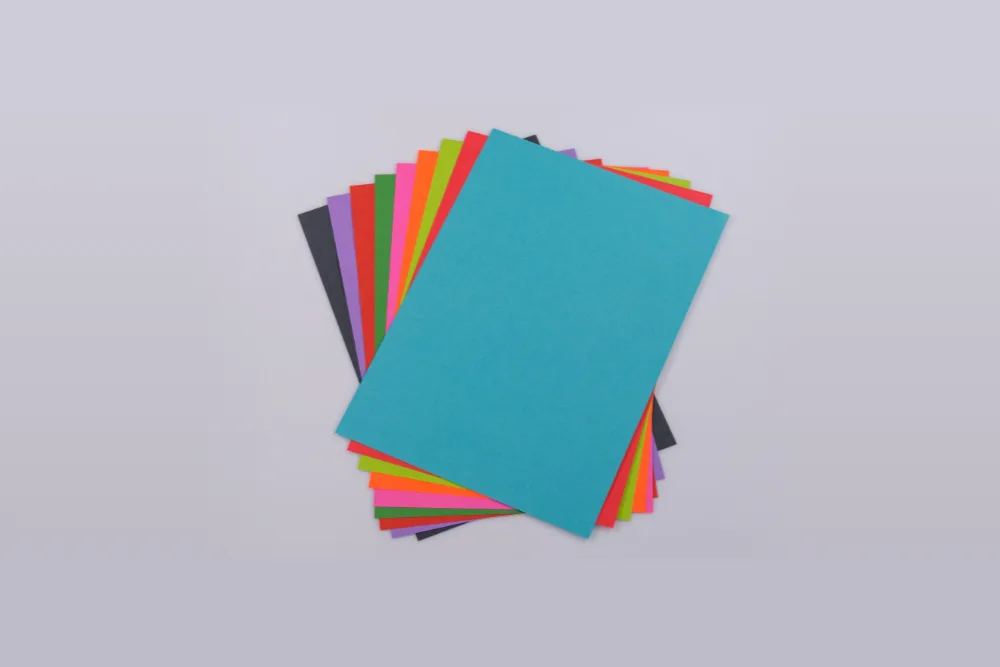 A neat fan of coloured sheets in about ten colours on a plain grey background