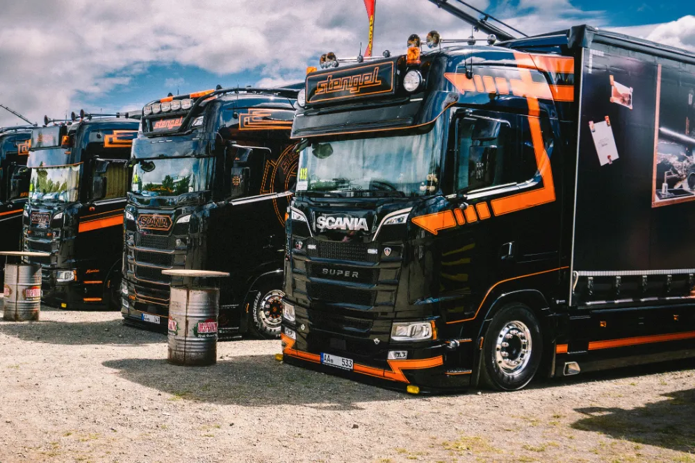 A row of black trucks in matching orange fleet livery